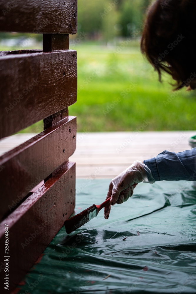 Painting red paint outdoors in summer