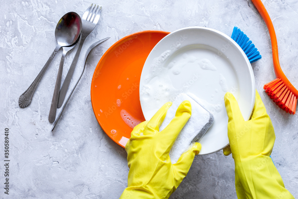 concept of woman washing dishes on gray background top view