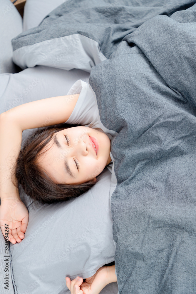 Asian little girl sleeping in bed