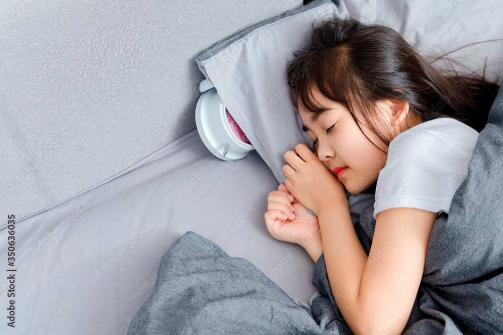 Asian little girl sleeping in bed