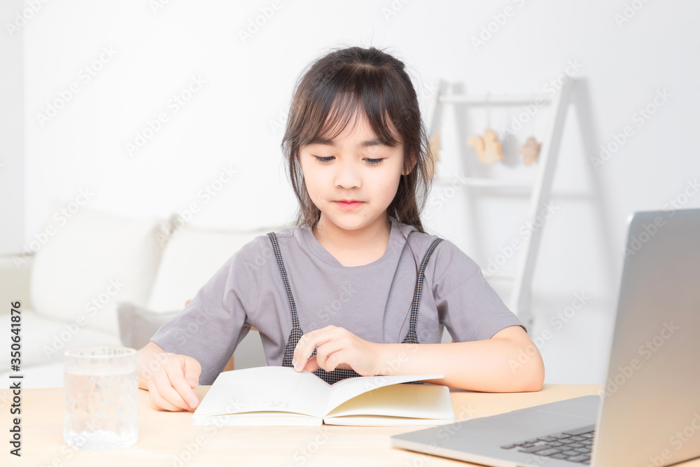 Asian little girl surfing internet at home