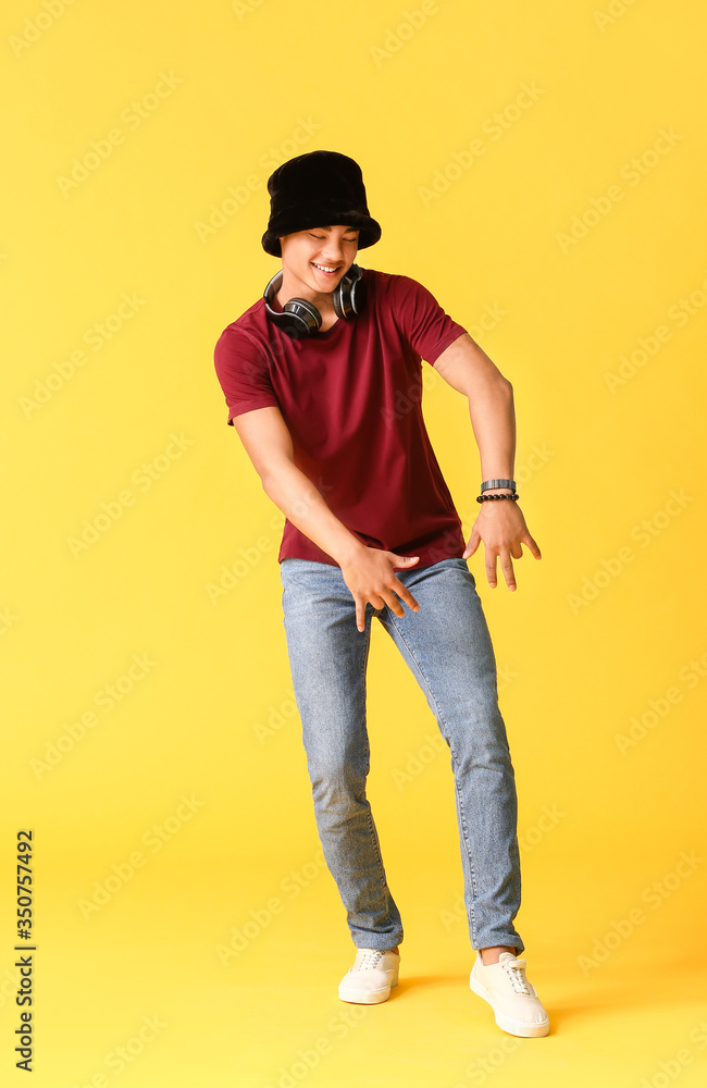 African-American teenager dancing against color background