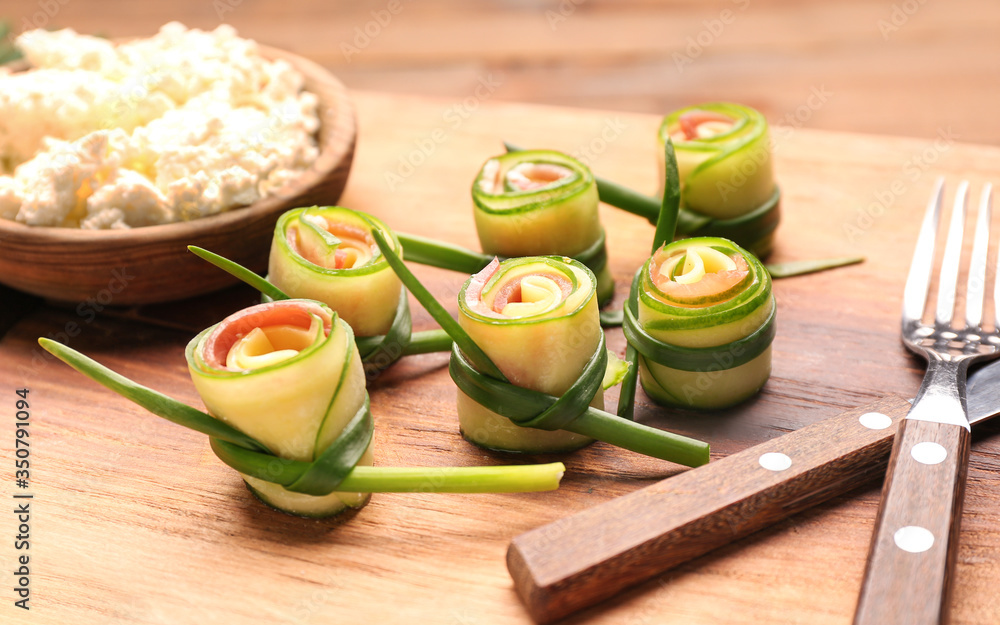 Tasty cucumber rolls on wooden board