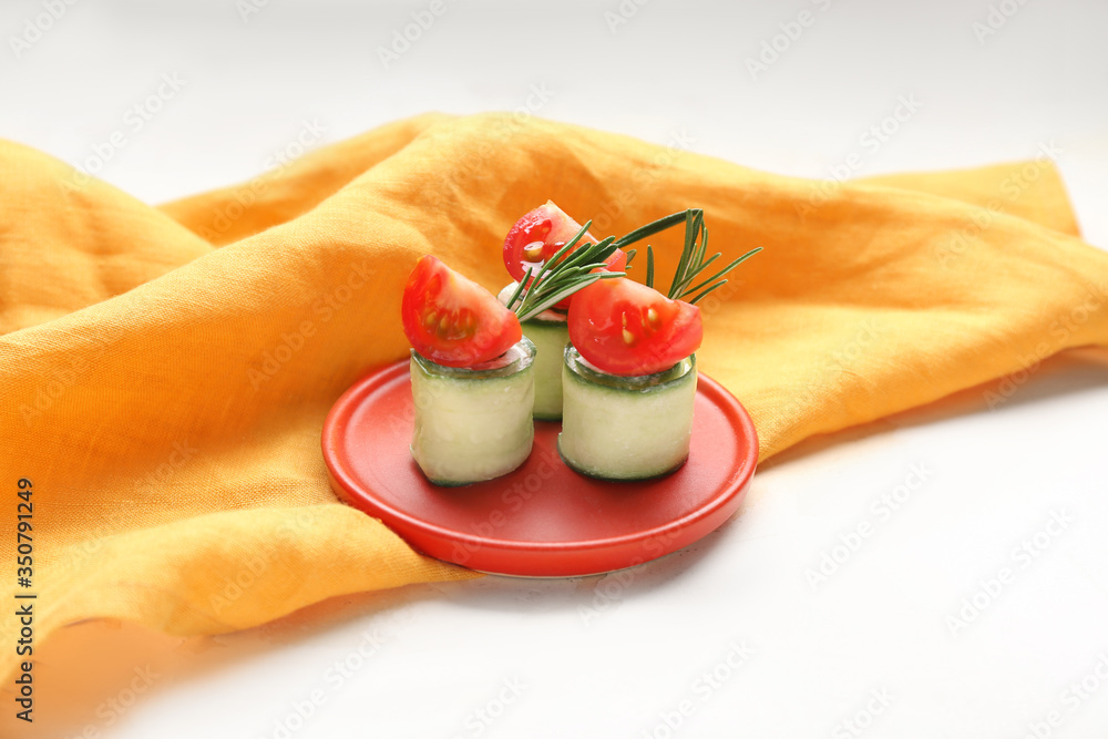 Plate with tasty cucumber rolls on white background