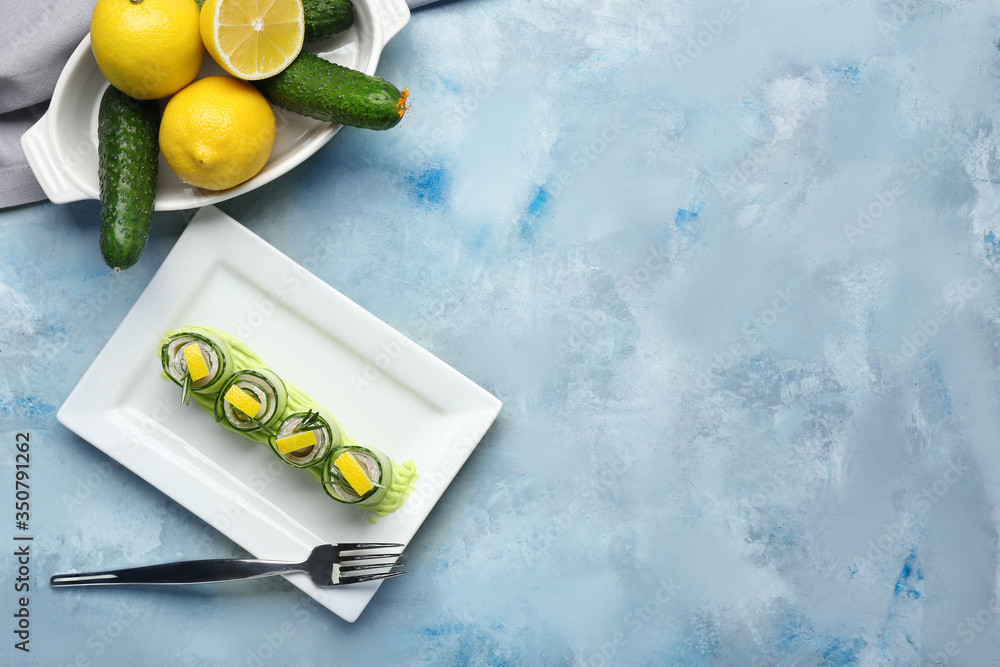 Plate with tasty cucumber rolls on color background