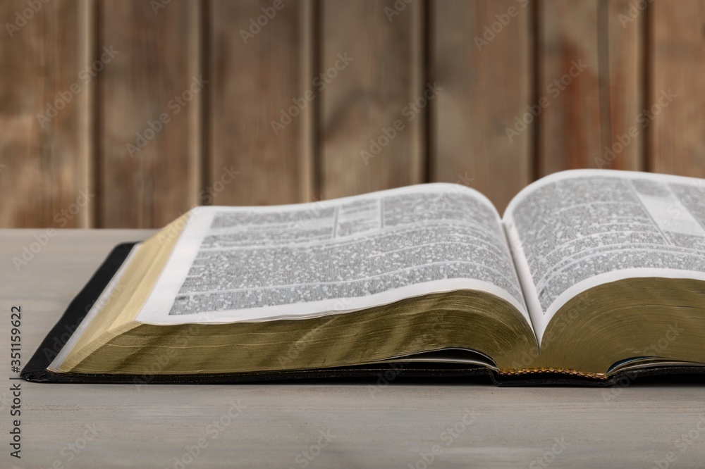 Open book on old wooden table.