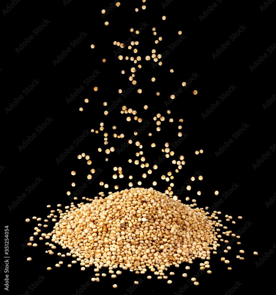 Falling quinoa seeds isolated on black background