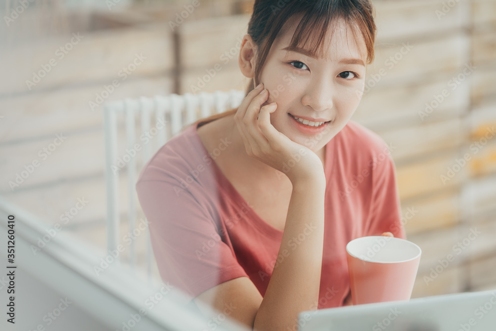 亚洲女子早上在阳台上阅读文件