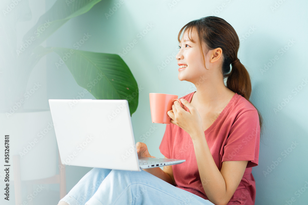 Asian woman sitting on the floor while she working from home