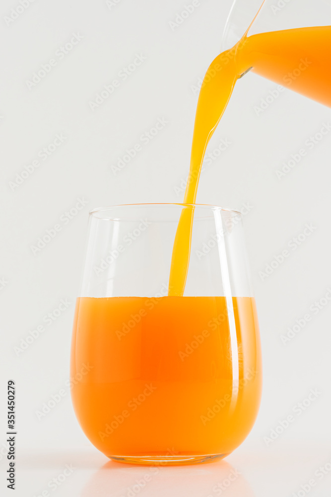 Pouring fresh organic orange juice into a glass