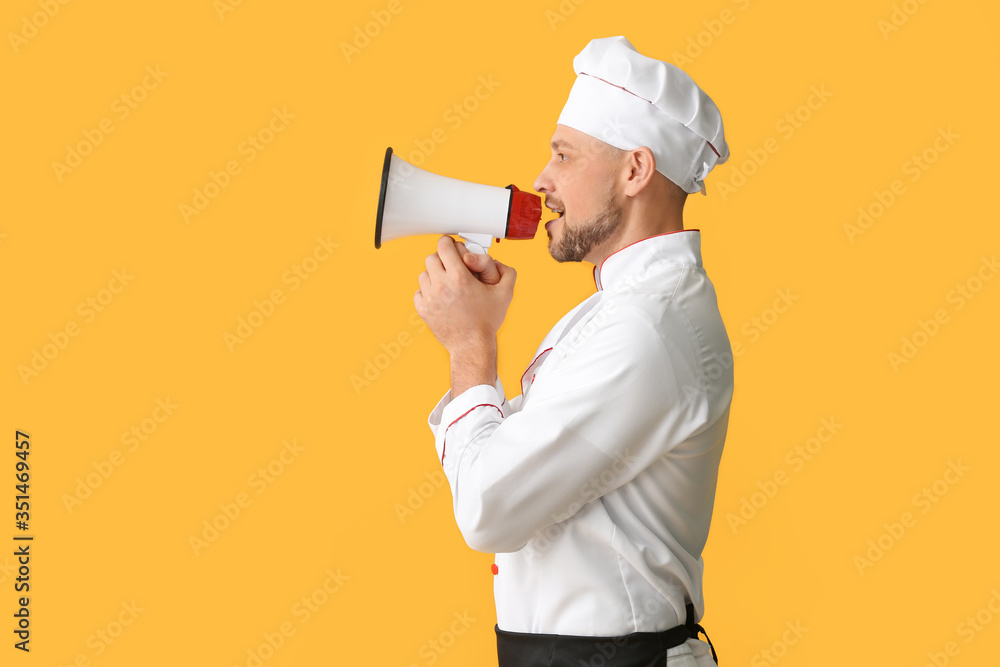 Portrait of male chef with megaphone on color background