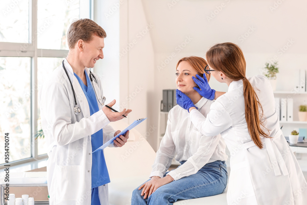 Plastic surgeons examining woman in clinic