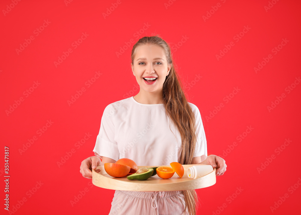 Young woman with healthy products on color background. Diet concept