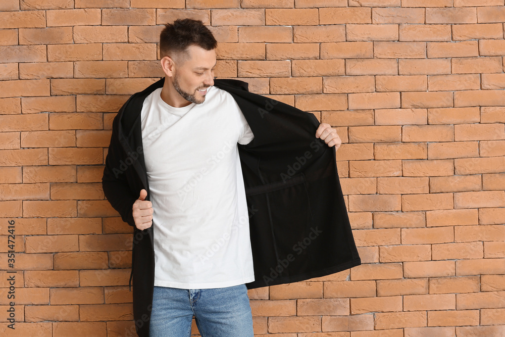 Man in stylish t-shirt near brick wall