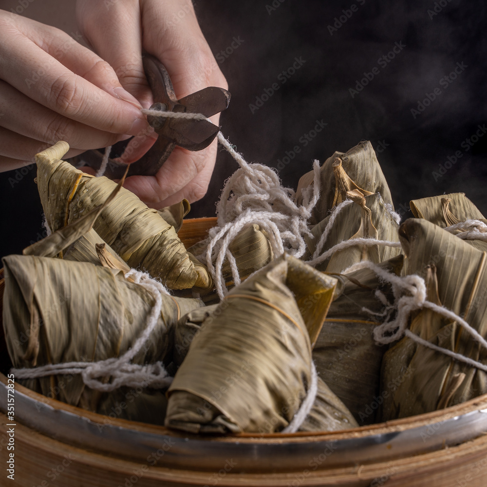 粽子，粽子——黑色背景下木桌上的一包中国传统熟食