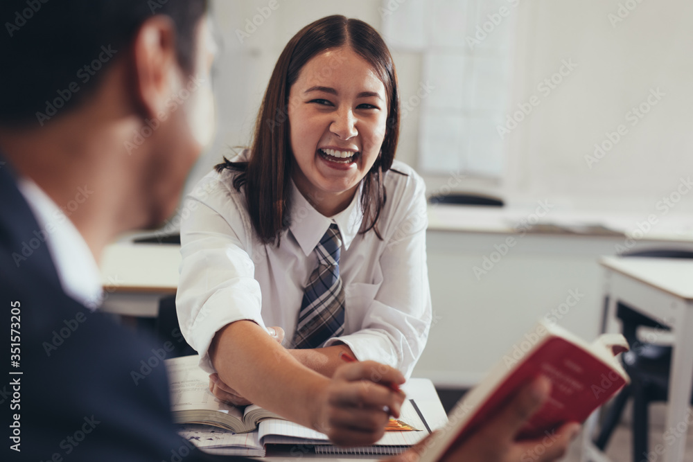 两个学生在课堂上谈笑风生