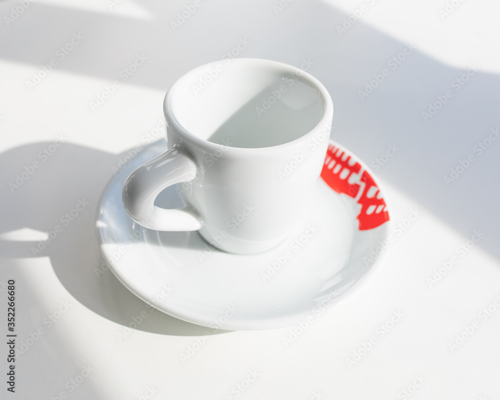 Empty white espresso cup with colored elements