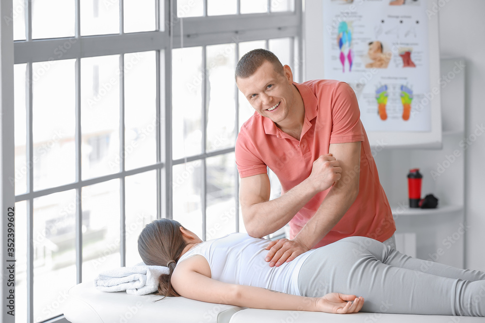 Massage therapist working with female patient in medical center