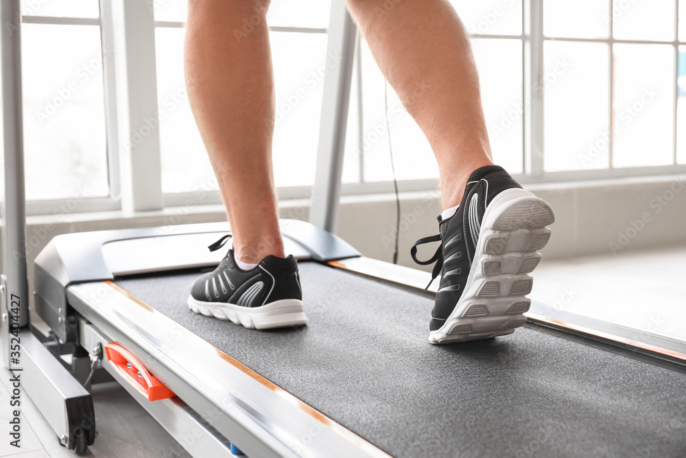 Senior man training on treadmill at home