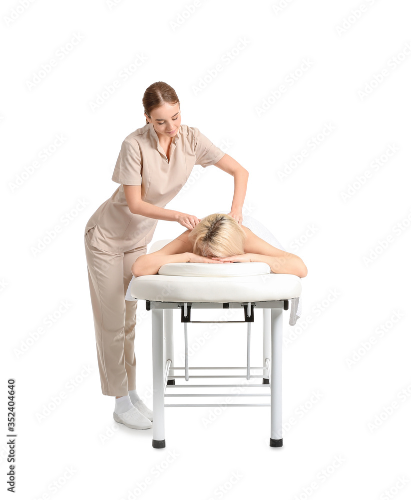 Massage therapist working with female patient on white background