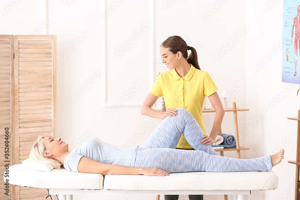 Massage therapist working with female patient in medical center