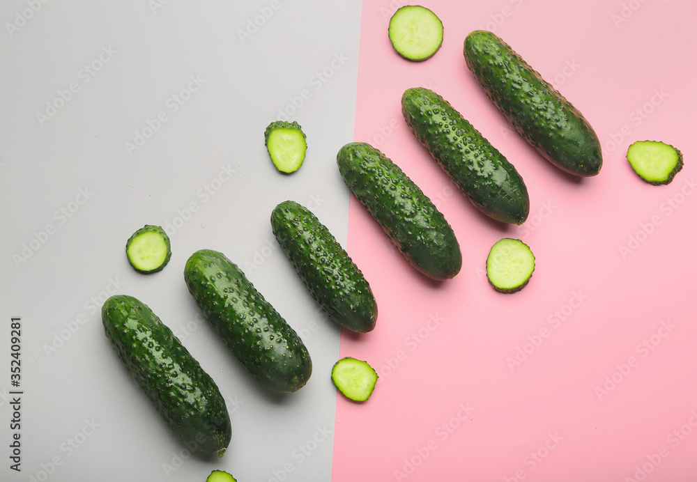 Fresh green cucumbers on color background