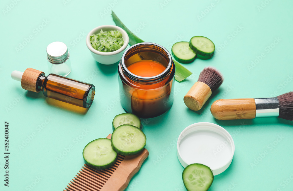 Composition with cucumber and cosmetics on color background