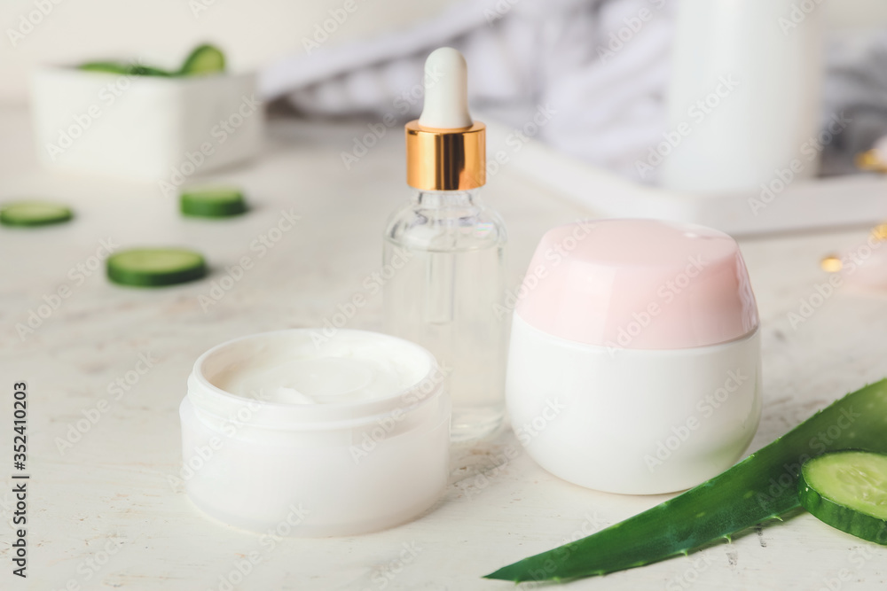 Cosmetics with cucumber extract on table