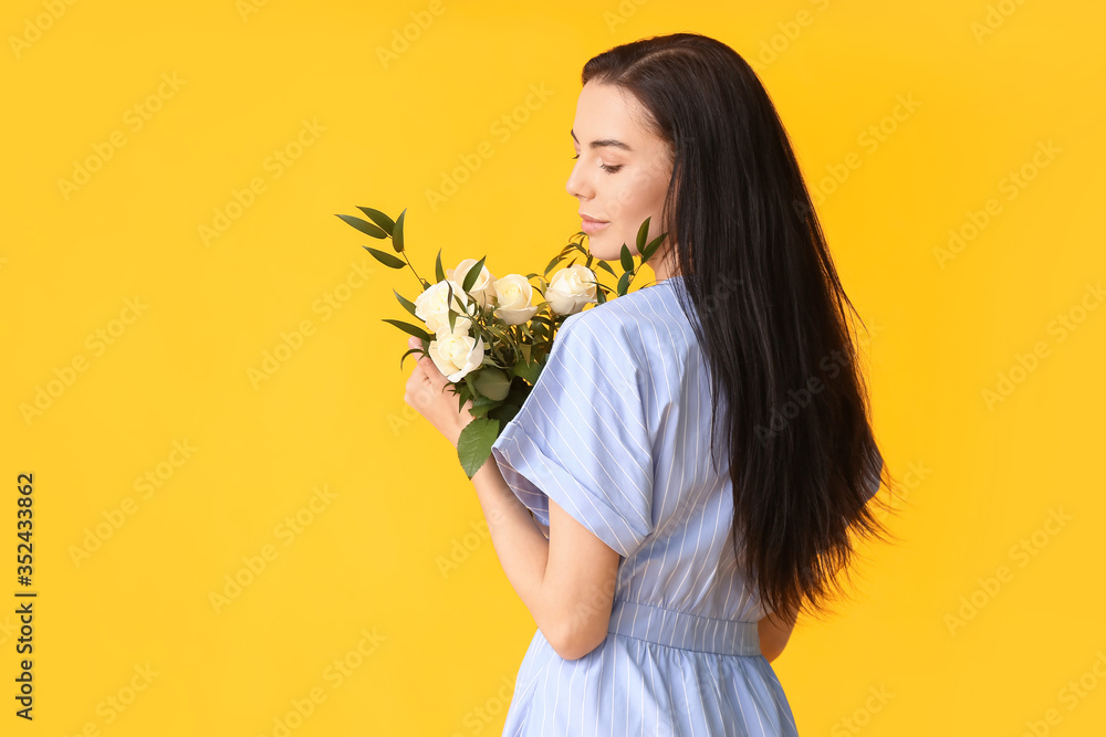 Beautiful young woman with bouquet of roses on color background