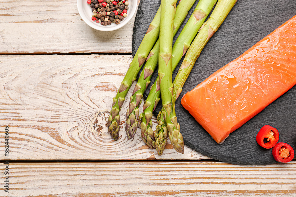 Asparagus with salmon, chili pepper and spices on table