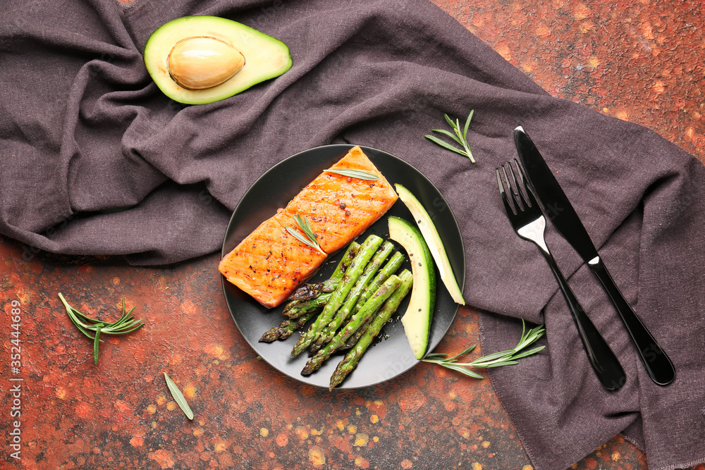 Cooked asparagus with salmon and avocado on color background