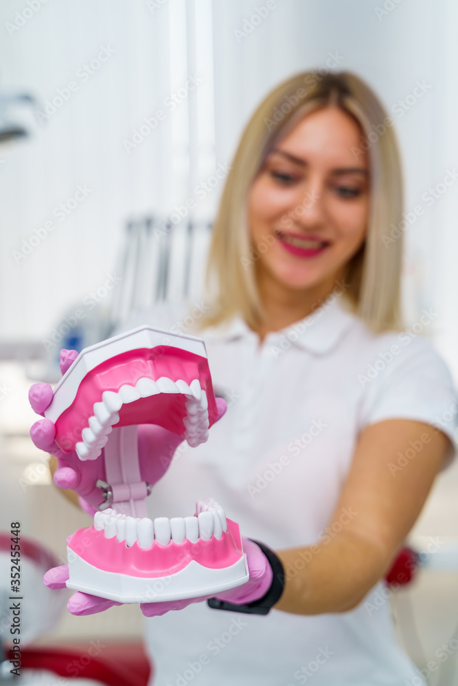 The dentist is holding dentures in his hands. Dental prosthesis in the hands of the doctor close-up.