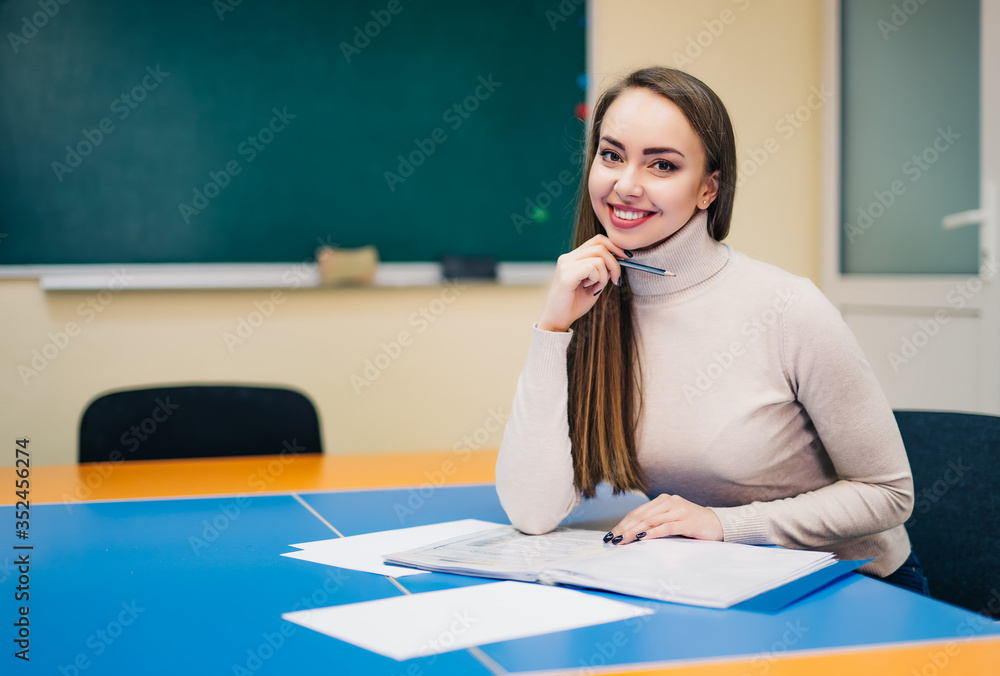 校园里的大学生。绿色墙上黑板上微笑的女学生或女教师肖像b