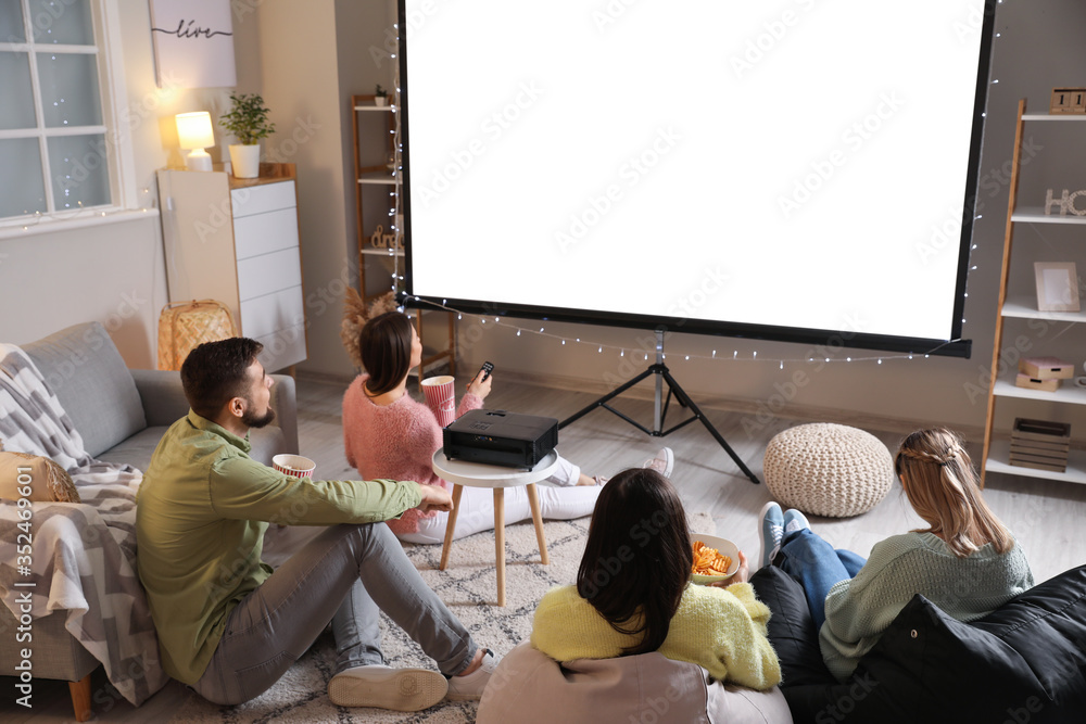 Young friends watching movie at home