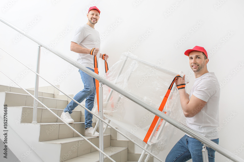 Loaders carrying furniture in the stairway