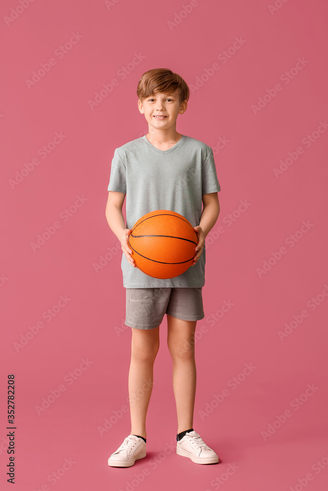 Cute little basketball player on color background