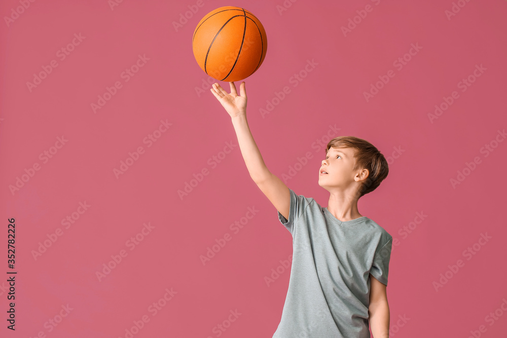 Cute little basketball player on color background