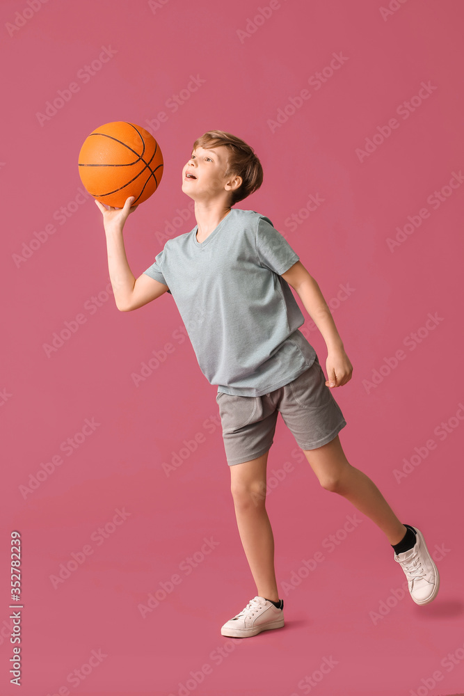 Cute little basketball player on color background