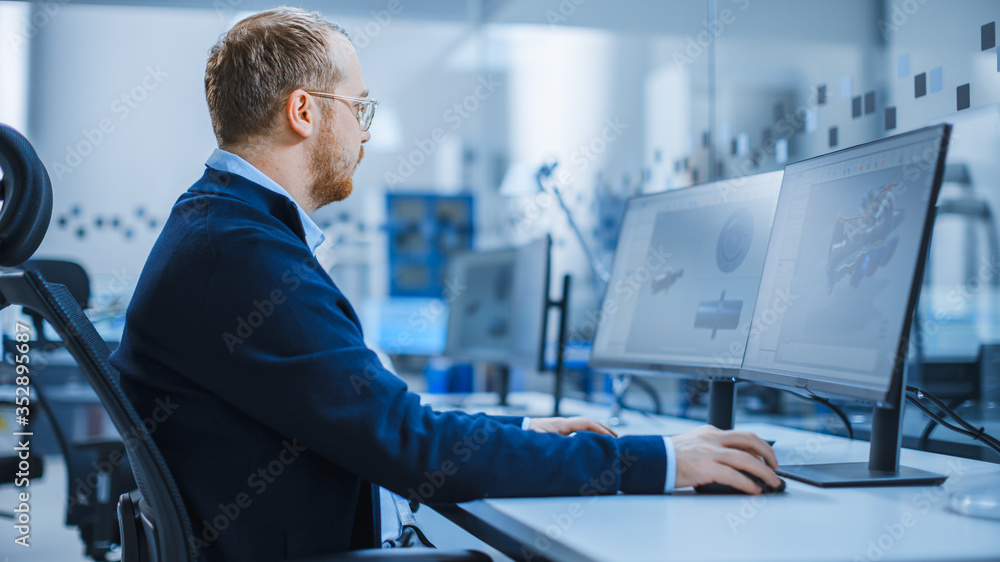 Industrial Engineer Working on a Personal Computer with Two Monitors Showing CAD Software with 3D Pr