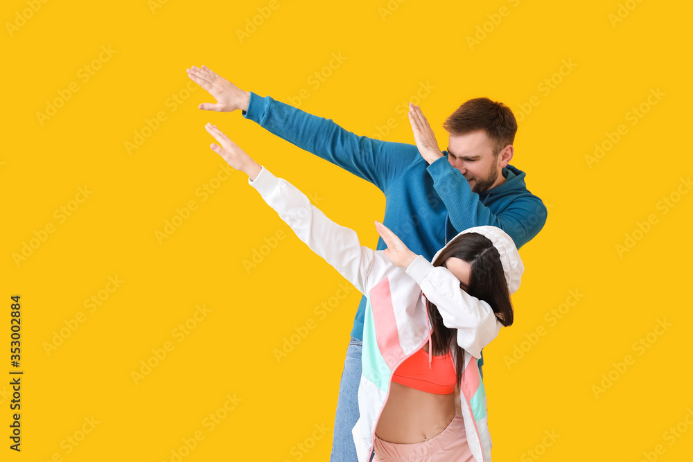 Happy young couple dancing against color background