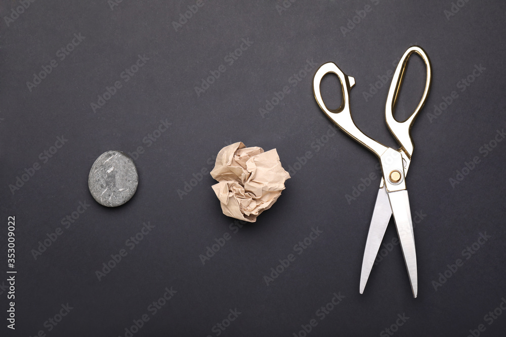 Scissors, rock and paper on dark background