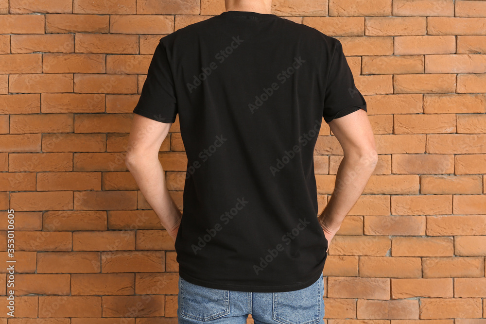 Man in stylish t-shirt near brick wall