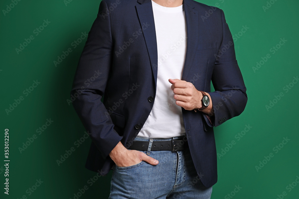 Handsome young man in stylish clothes on color background