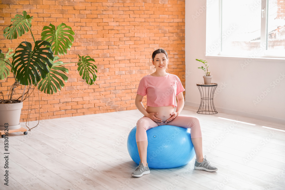 Beautiful pregnant woman training in gym