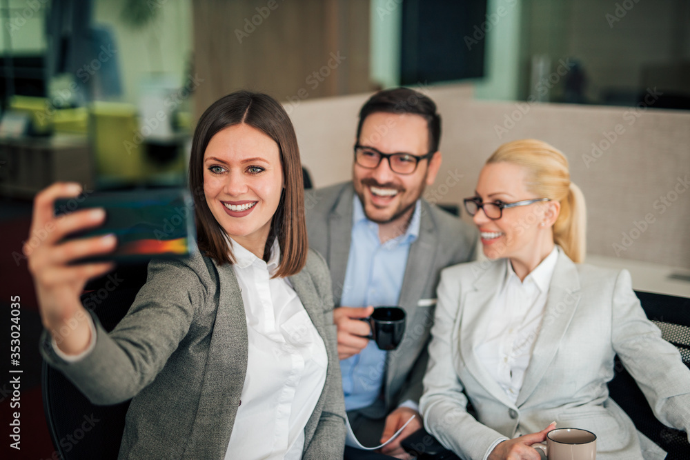 Smiling business team taking selfie.