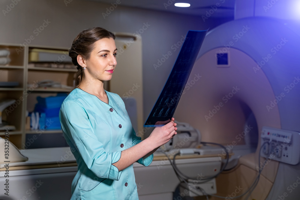 Doctor explaining an x-ray image near the magnetic resonance imaging machine.