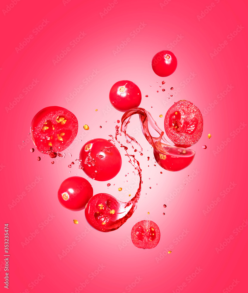 Whole and sliced cranberries with splashes of juice on a red background