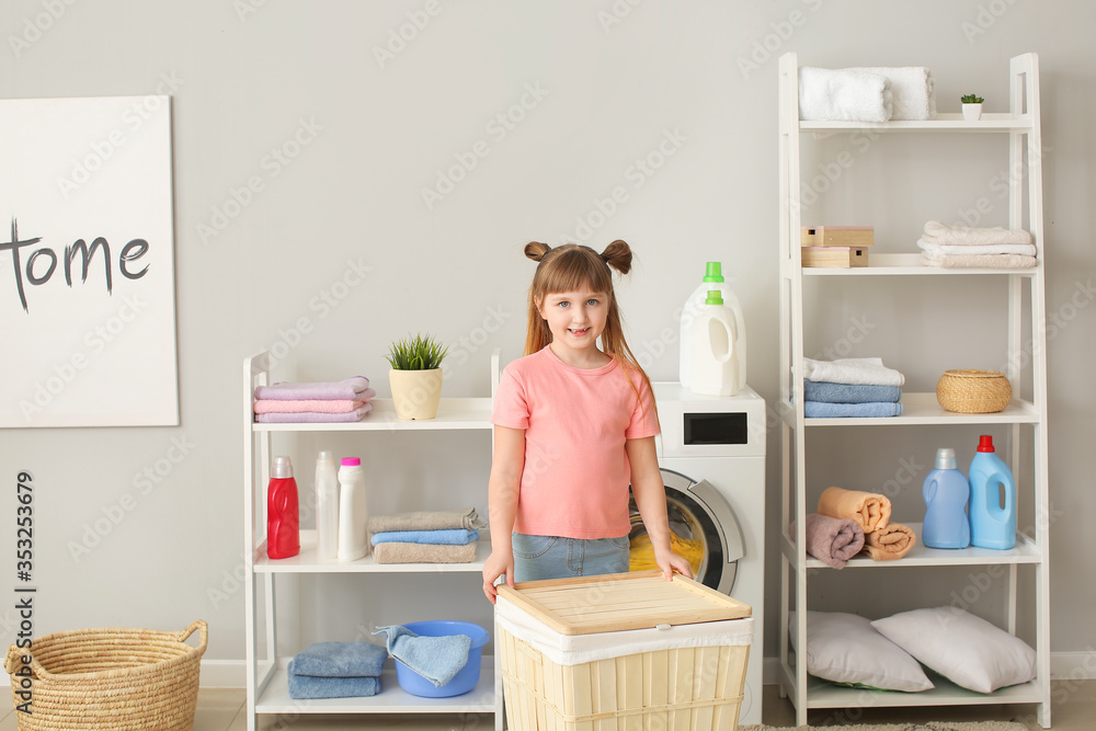 Cute little girl doing laundry at home