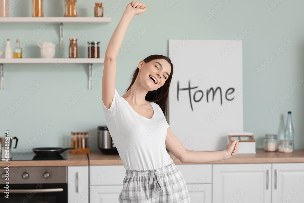 Beautiful young woman dancing in kitchen