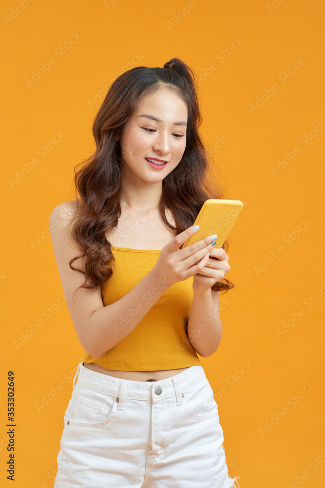 Photo of funny pretty lady hold telephone hands wear white tank-top jeans isolated bright yellow col